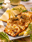 Weihnachtskuchen mitTrockenfrüchten und Nüssen serviert dazu würziger Käse