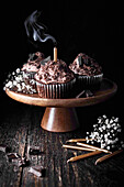 Muffins mit Schokoladencreme und ausgepusteter goldener Kerze