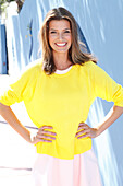 A young woman wearing a white dress and yellow jumper