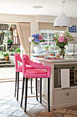 Kücheninsel und pinkfarbenen Barhockern
