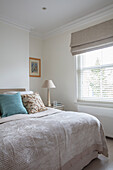 Queen bed with bedspread and bedside table in the bedroom