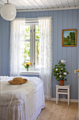 Nostalgic bedroom with light blue painted wood paneling