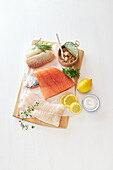 Different kinds of fish - pollack fillet, tuna, salmon fillet, cod fillet on a wooden board