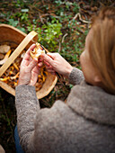 Woman checking mushroom in the forest