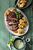 Braised leg of lamb with asparagus pakora fritters, and mint sauce