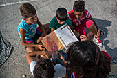 Children listening to a story at a refugee camp, Greece