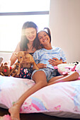 Happy disabled daughter with mother and dog on bed