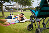 Mother and disabled daughter laying and talking in park