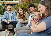 Happy friends with dog on patio