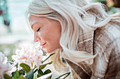 Smiling woman smelling flower
