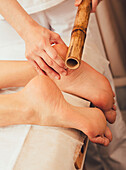 Foot massage with bamboo sticks