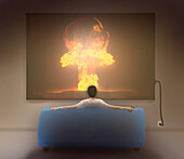 Man watching nuclear explosion on a television, illustration