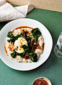 Spicy miso porridge with leaf spinach, poached egg and chili oil