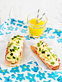 Toast with ham, cheese and cucumber with glass of orange juice