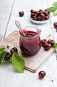 Small Jar of Cherry and Coconut Preserves with Fresh Cherries