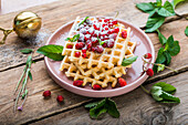 Waffles with wild strawberries, red currants, and confectionery sugar