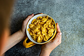 Bowl of cornflakes on a concrete counter top
