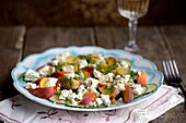 Hearty summer salad with peaches, cucumber, feta, dill and citrus dressing