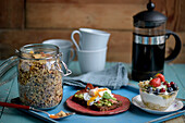 Granola-Müsli, Avocado-Toast mit Ei und Joghurt mit frischen Beeren zum Frühstück