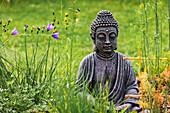 Buddha Statue aus Stein in einem Garten, Deutschland