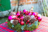 Christmas wreath decorated with ornaments on a plaid tablecloth