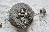Nest aus Steppenroller (auch Tumbleweed) mit natürlich gefärbten Ostereiern auf Keramikplatte