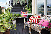 Cozy terrace with rattan chairs, bench, and potted plants