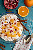 Rice pudding with pomegranate seeds, oranges and cinnamon