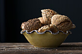 Assorted grain rolls in a bowl on a black background