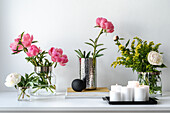 Peonies and goldenrod in glass vases and candle arrangement (Paeonia)