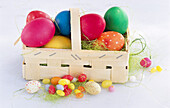 Basket with Easter eggs, with sugar eggs next to it