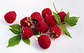 Raspberries and leaves on a light background