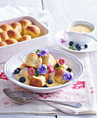 Sweet buns with vanilla sauce and blueberries