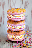 Cookie-Sandwich mit pinker Zuckerglasur und bunten Zuckerkonfetti