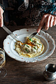 Woman eating raviolo con uovo with sage butter