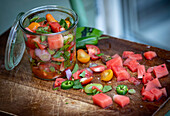 Watermelon salad with tomatoes and herbs in a jar