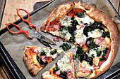 Gorgonzola pizza with kale and pancetta prepared using a pizza kit