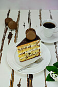 A piece of stracciatella cake decorated with chocolate macarons