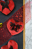 Herzförmige Johannisbeertörtchen dekoriert mit Schokoladenschmetterling
