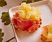 Puff pastry tartlets with ham and tete de moine