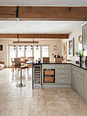 Light country-style fitted kitchen in the corner, dining area in the background