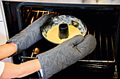 Putting a cake tin in the oven