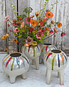 Blumenstrauß aus Nelkenwurz (Geum) in modernen Vasen