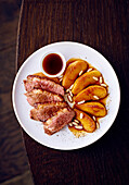 Pink roasted duck breast with apples