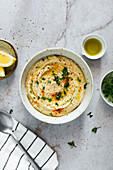 Chickpea hummus and ingredients, lemon, oil and parsley