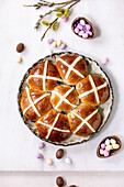 Homemade Easter traditional hot cross buns in ceramic dish with willow branches and chocolate candy eggs