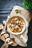 Chicken and mushroom risotto, served on a wooden kitchen board