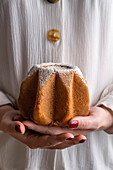 Hands holding a small pandoro being held in a womans hands
