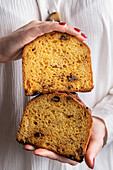 Hands holding two slices of panettone