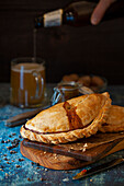 A Cornish pasty and a glass of beer being poured in the background